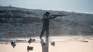 охотник наблюдает за животными на фоне леса