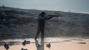 Охотник наблюдает перелёт уток из укрытия