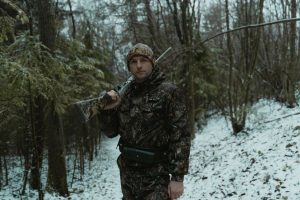 охотник сверяет маршрут перед выходом в заснеженный лес