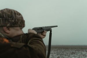 охотник оценивает посадку ружья у прилавка