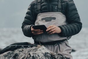 рыболов сверяет место ловли с картой берега