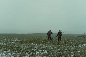 охотники идут по осенней тропе в угодьях